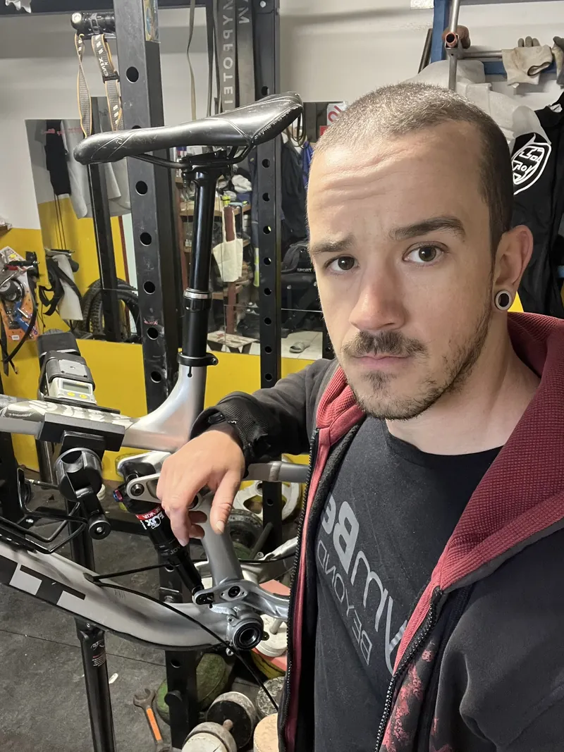 Tomáš v dielni s bicyklom na stojane